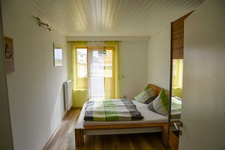 Ferienwohnung 08 - Schlafzimmer 1 mit Doppelbett und ausreichend Stauraum