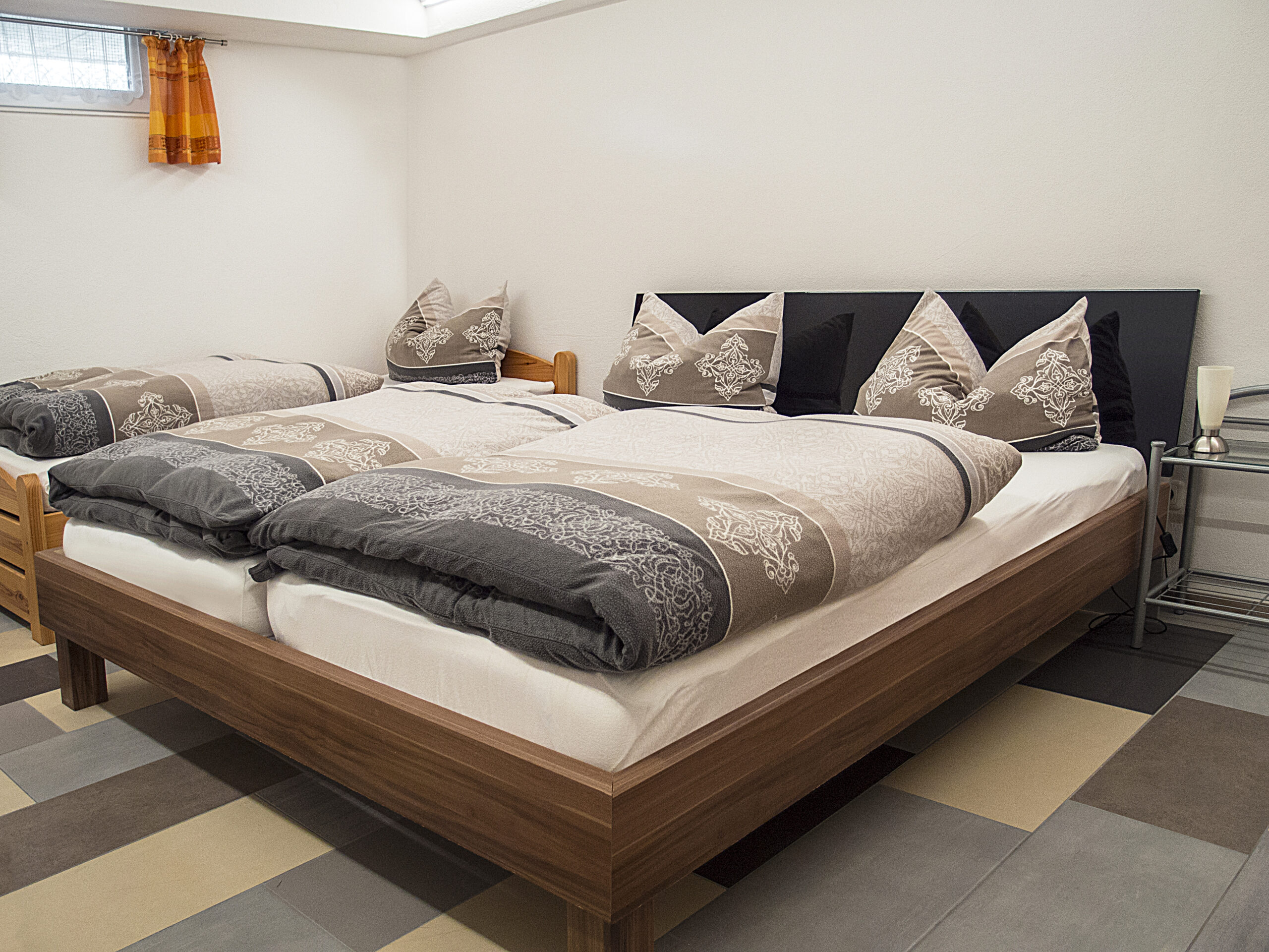 Keller-Ferienwohnung - Schlafzimmer mit Doppelbett und Einzelbett